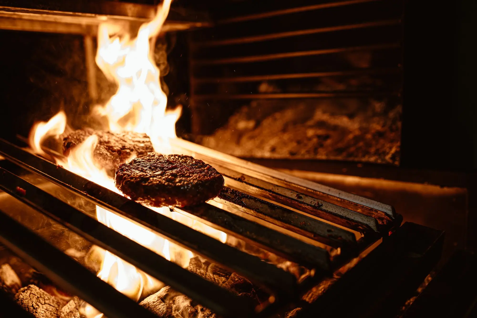 Hamburguesa a la brasa con queso fundido sobre fondo oscuro